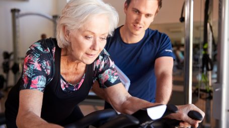 Senior vrouw krijgt fitnesssbegeleiding