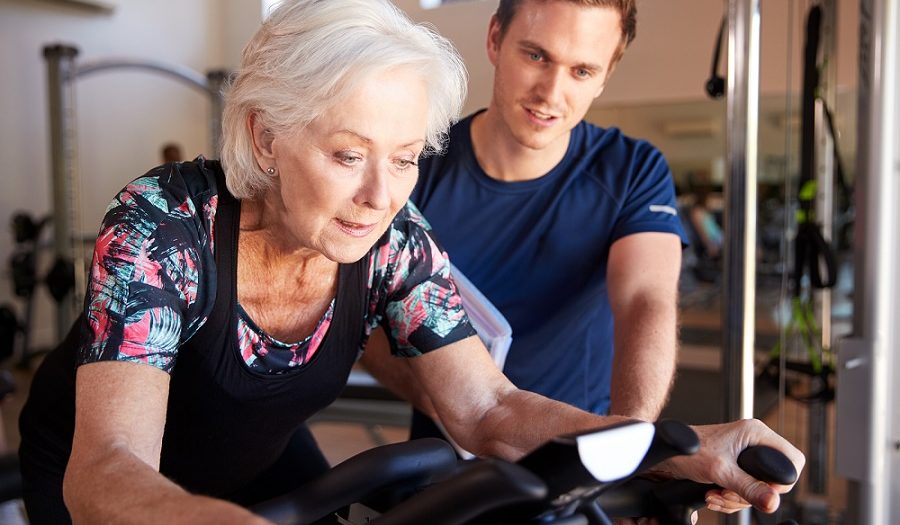 Senior vrouw krijgt fitnesssbegeleiding