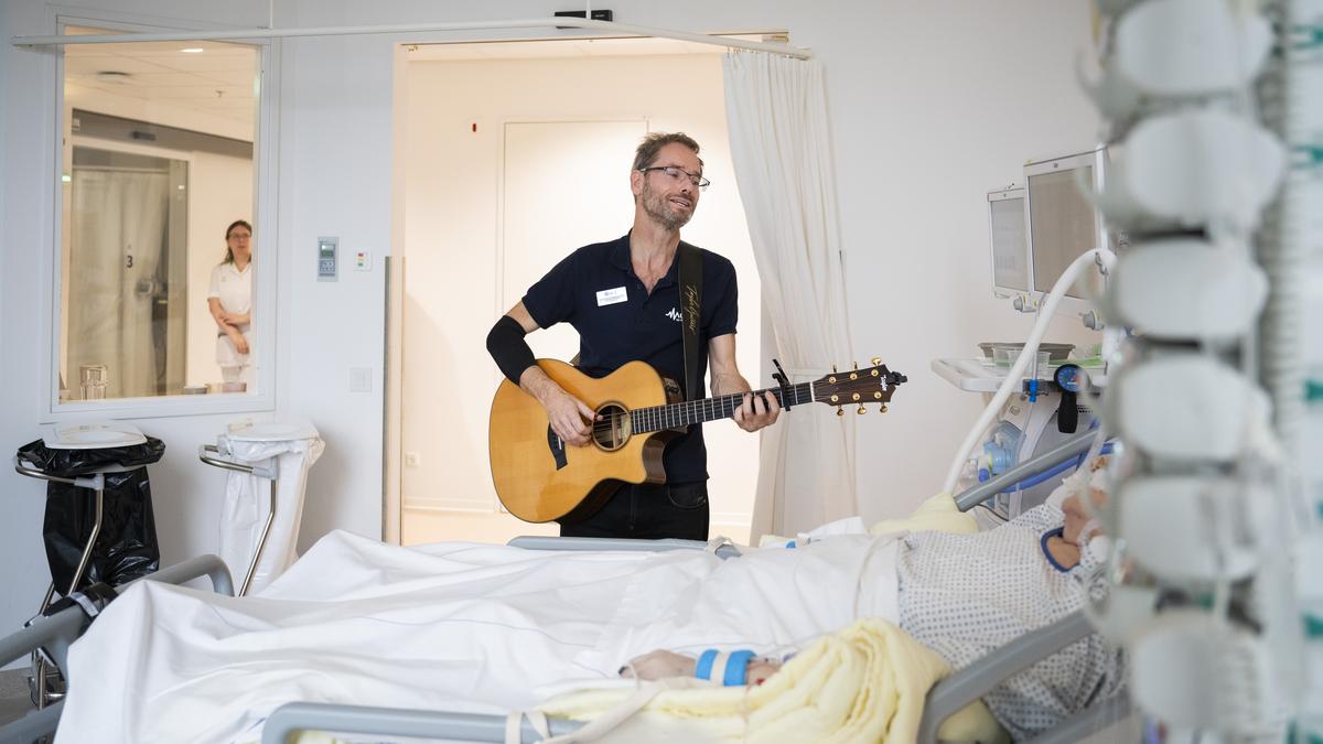 Kurt Efting zingt en speelt gitaar voor een ernstig zieke patiënt op de IC